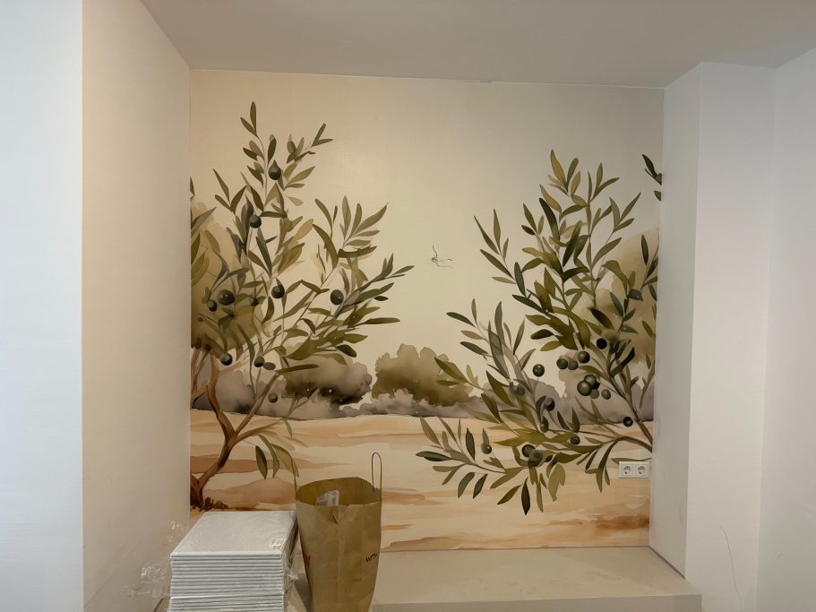 Wandgestaltung mit olivenbaumartigen Pflanzenmotiven in sanften Farben.